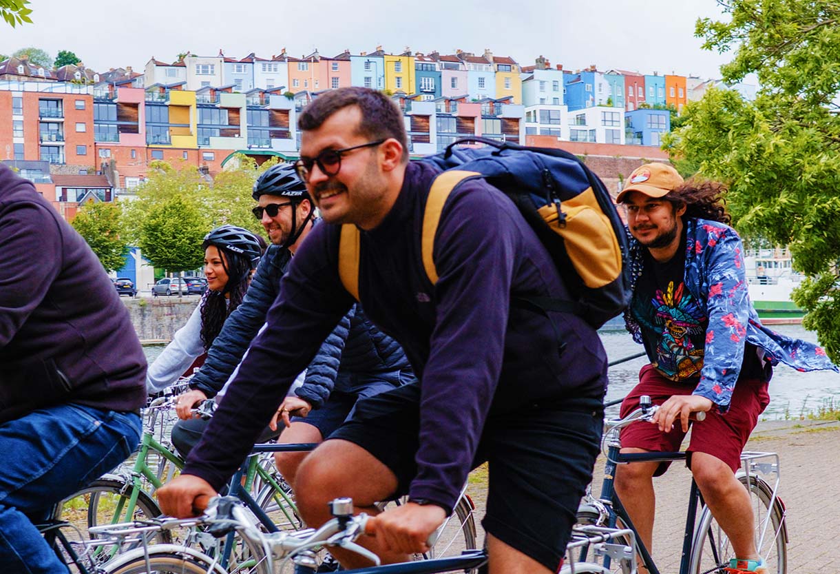 the Bristol Bike Tour Guests cycling alongside beautiful multicoloured houses